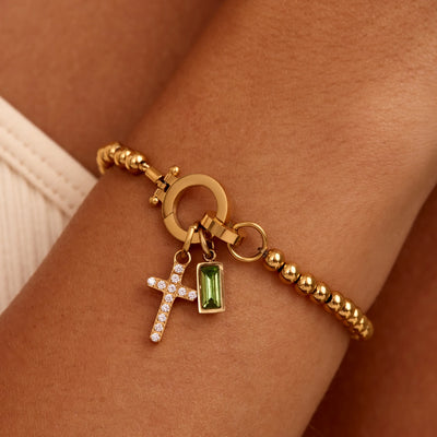 Pulsera con dije de cruz y cuentas de piedra de nacimiento